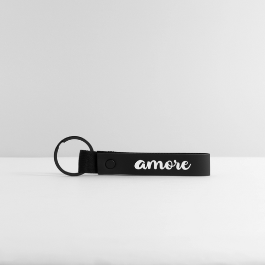 Schwarzer Schlüsselanhänger mit weißem „Amore“-Schriftzug in Kursivschrift, großer Schlaufe und matter Oberfläche – minimalistisch auf weißem Hintergrund