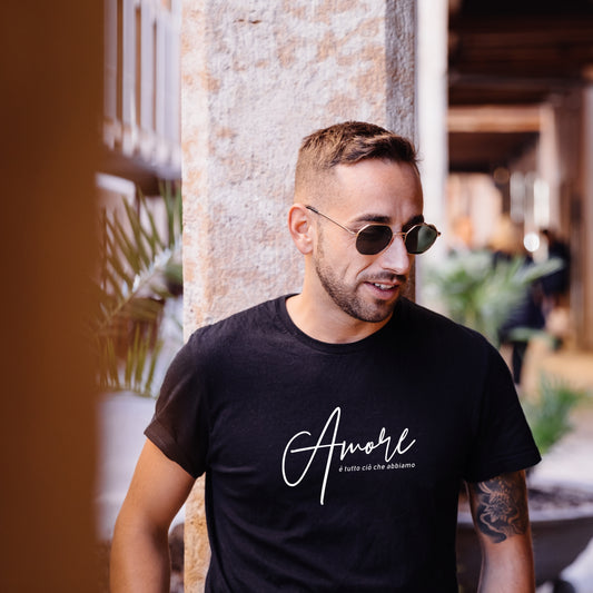 Schwarzes Unisex-T-Shirt aus 100 % Bio-Baumwolle mit weißem „Amore – è tutto ciò che abbiamo“-Print. Nachhaltige Streetwear mit Herz und Haltung – bequem, hochwertig, emotional.