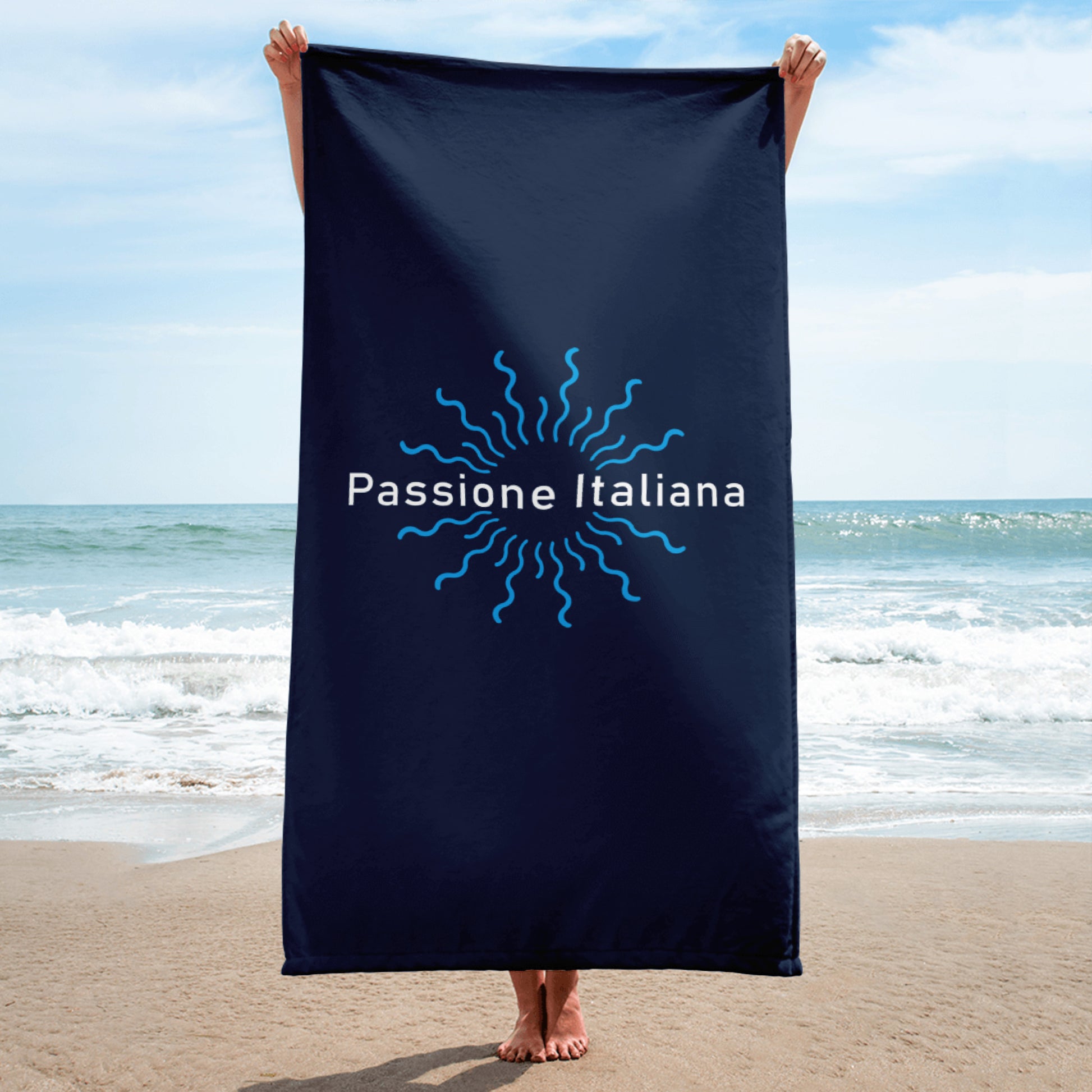 Dunkelblaues Handtuch mit Sonnenmotiv und „Passione Italiana“-Schriftzug am Strand – mediterranes Lebensgefühl in Szene gesetzt.