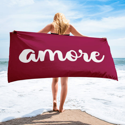 Person hält bordeauxfarbenes Handtuch mit weißem „Amore“- – Liebesbotschaft trifft italienisches Design.
