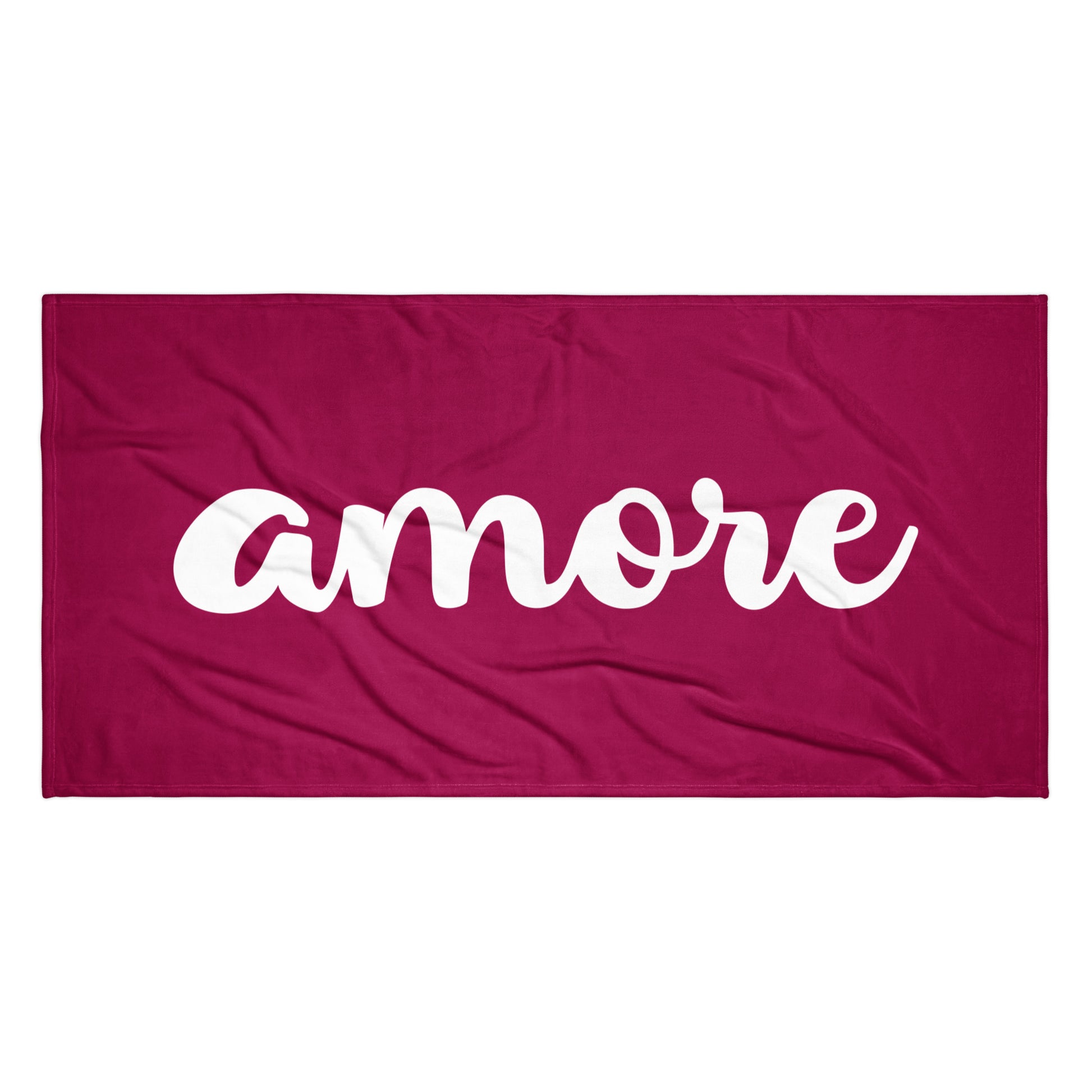 Bordeauxfarbenes Handtuch mit weißem „Amore“-Schriftzug am Strand – Liebesbotschaft trifft italienisches Design.