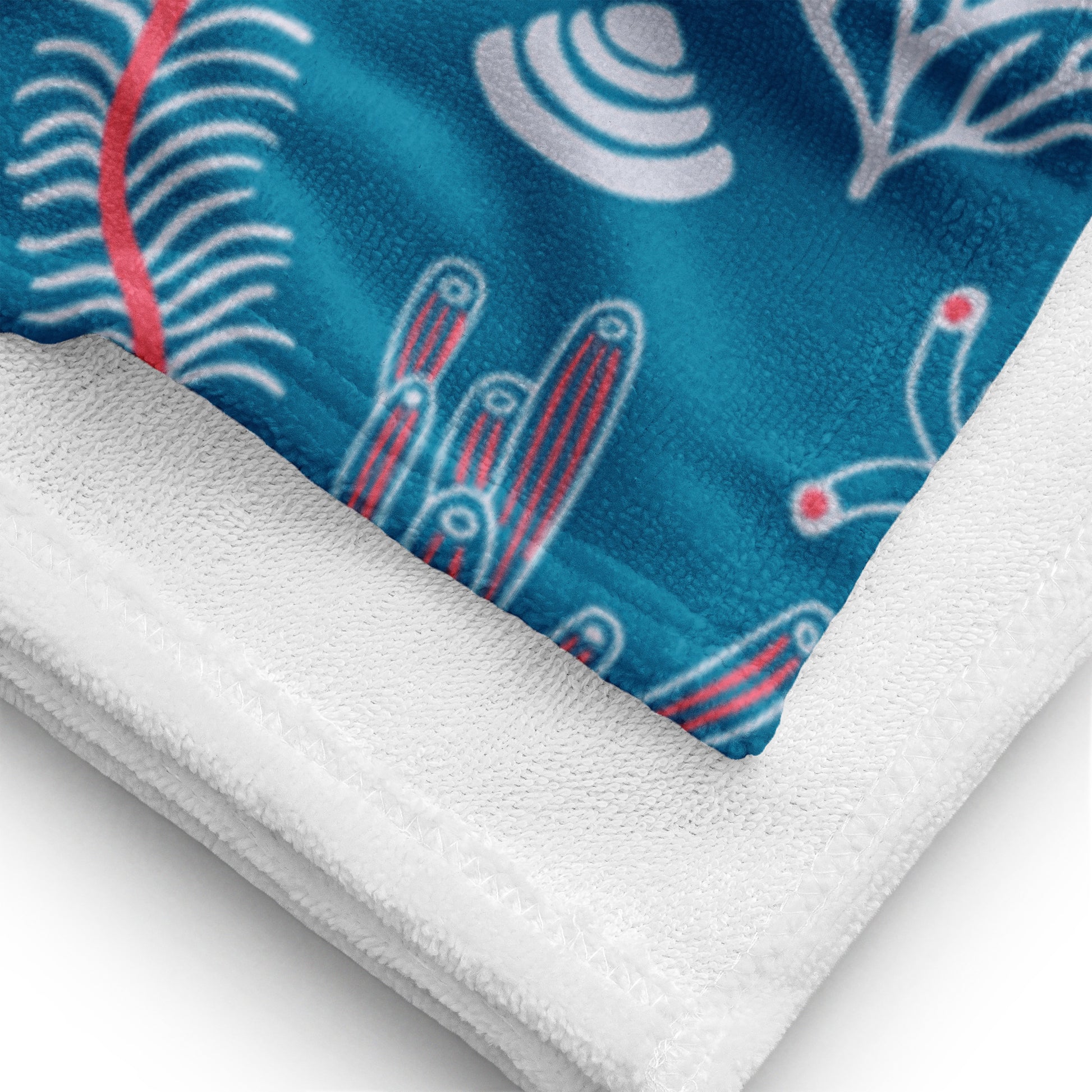 Handtuch mit Unterwasser-Illustrationen in Weiß, Pink und Hellblau auf türkisfarbenem Stoff Detailansicht