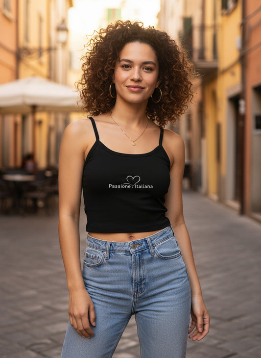 Schwarzes Damen-Crop-Top mit dünnen Trägern und weißem „Passione Italiana“-Schriftzug samt Herzmotiv; getragen mit Jeans in italienischer Altstadt – modisches Statement für Streetwear, Selbstbewusstsein und kulturelle Verbundenheit.