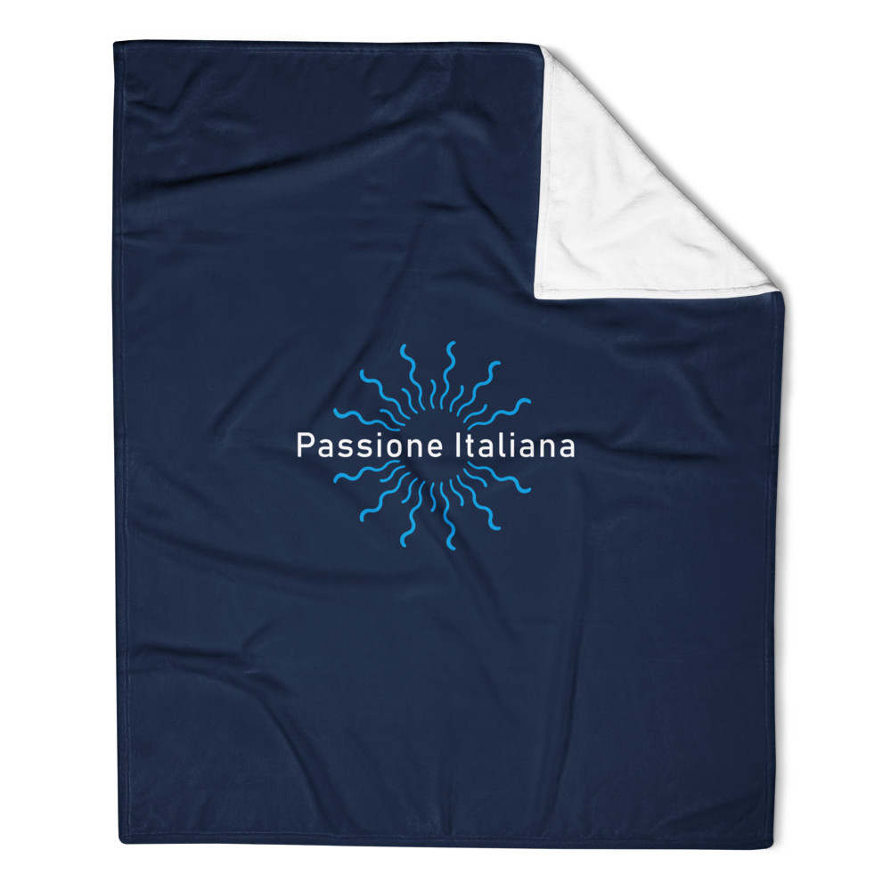Dunkelblaue Kuscheldecke mit weißem Innenfutter und Passione Italiana Logo in Sonnenstrahlen-Design, gefaltet auf Sofa