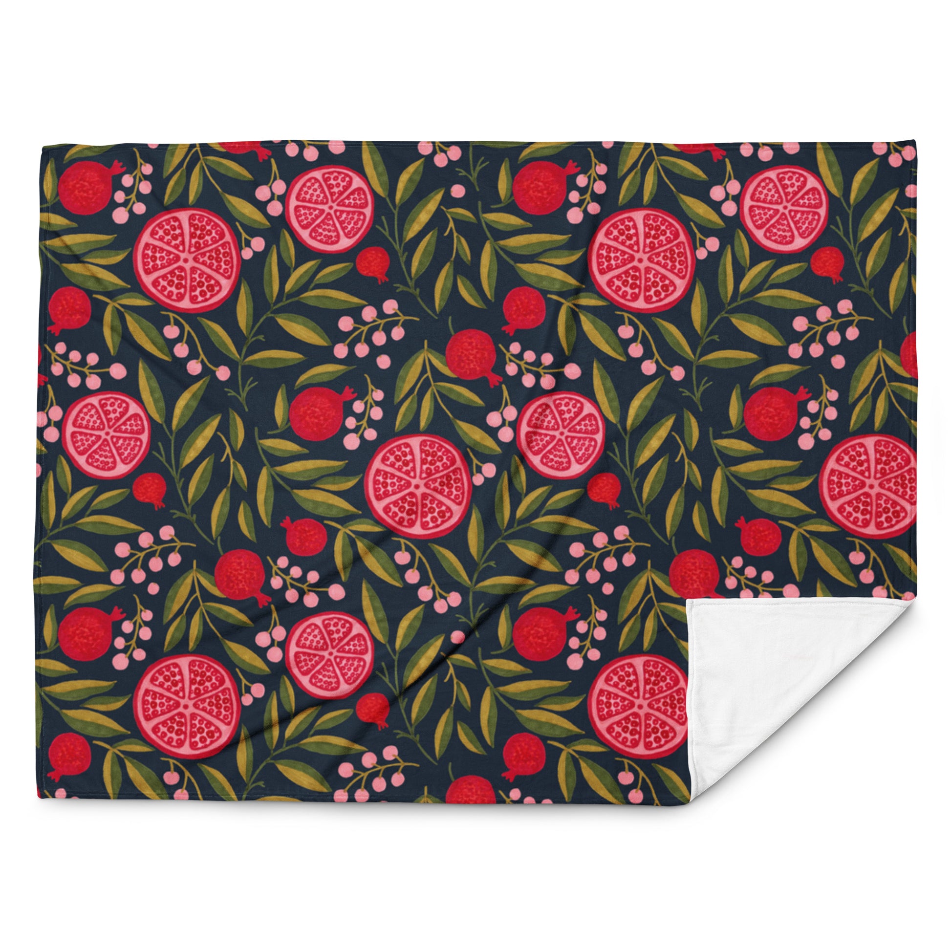 Kuscheldecke mit roten Früchten, grünen Blättern und dunklem Hintergrund als Interior-Highlight

