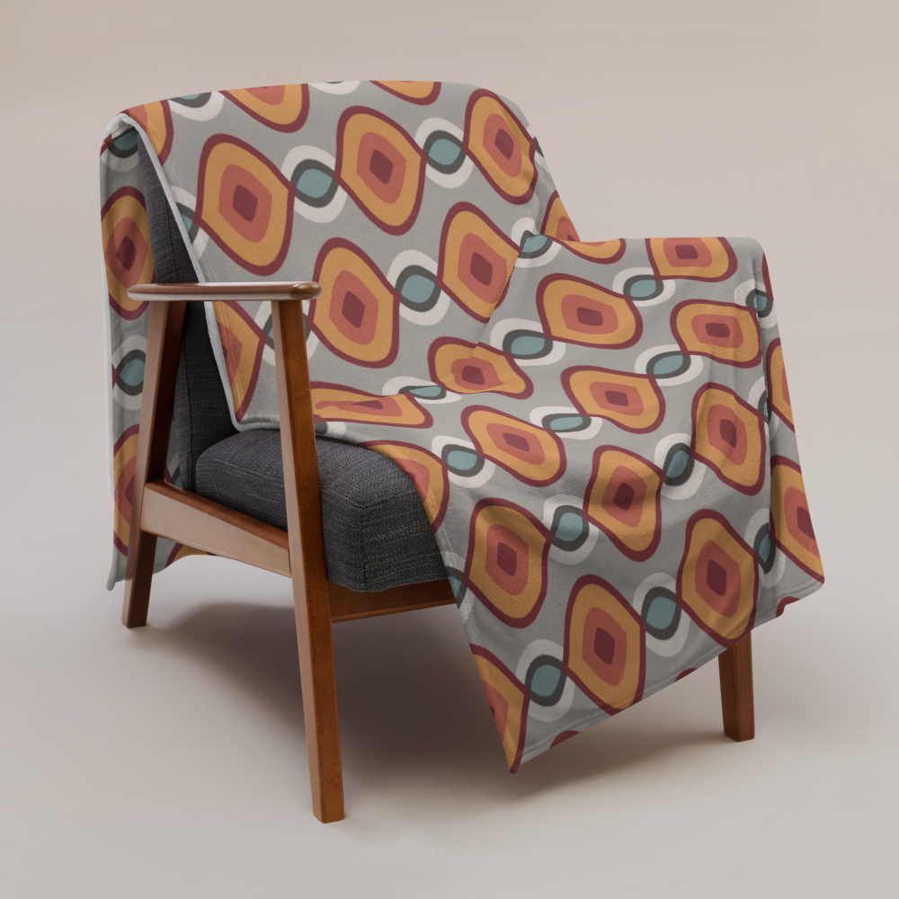 Decke mit folkloristisch inspiriertem Print und weißer Rückseite